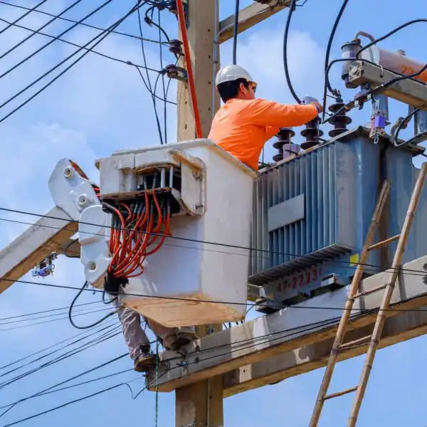 electrician working on electrical transmission on power pole
