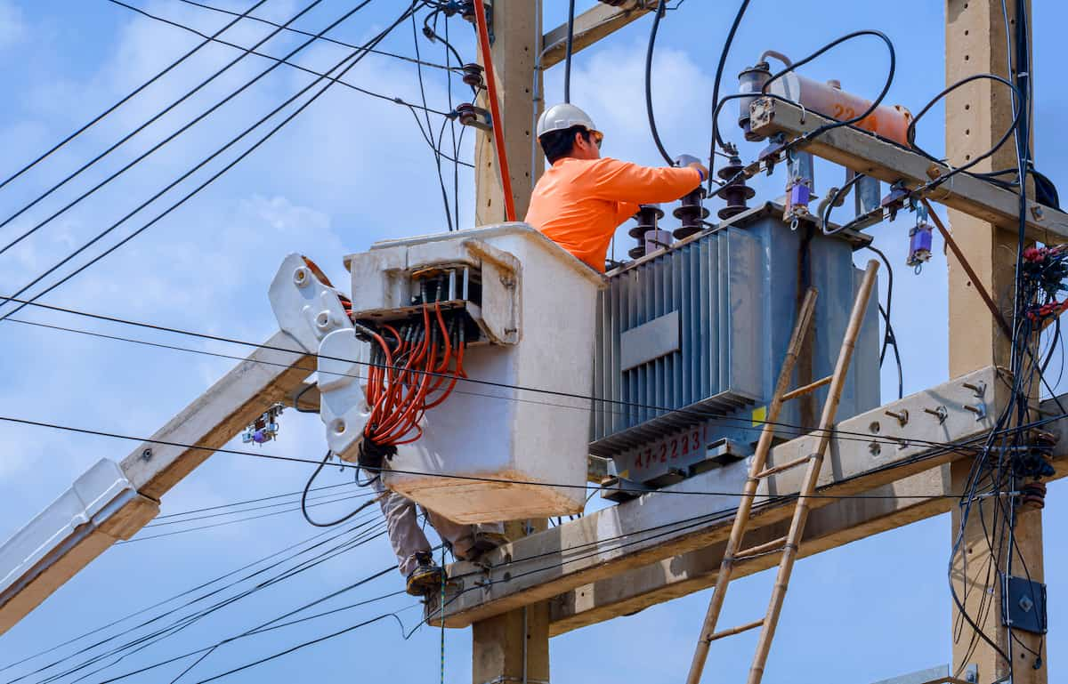 electrician working on electrical transmission on power pole