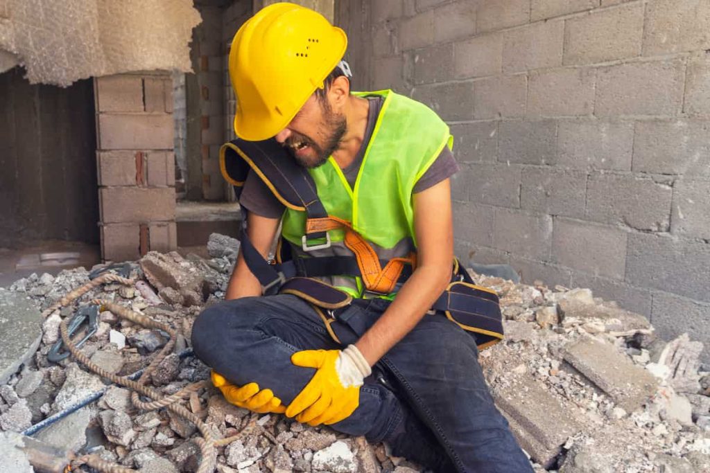 injured construction worker holding his knee