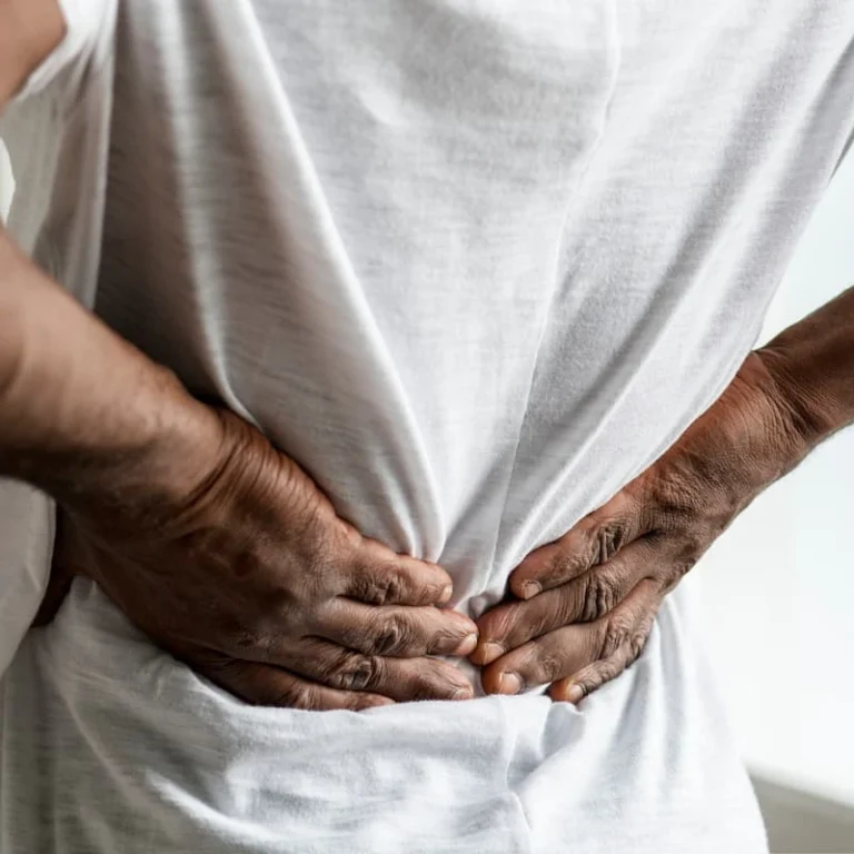 Person holding lower back in pain, illustrating a work-related back injury claim in Missouri.