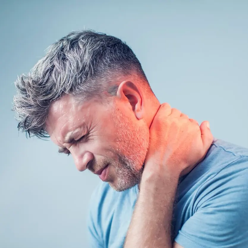 Man holding neck in pain, showing symptoms of a work-related neck injury and employer pressure to return to work in Missouri.